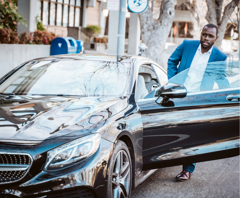 Executive stepping out of a chauffeured saloon car